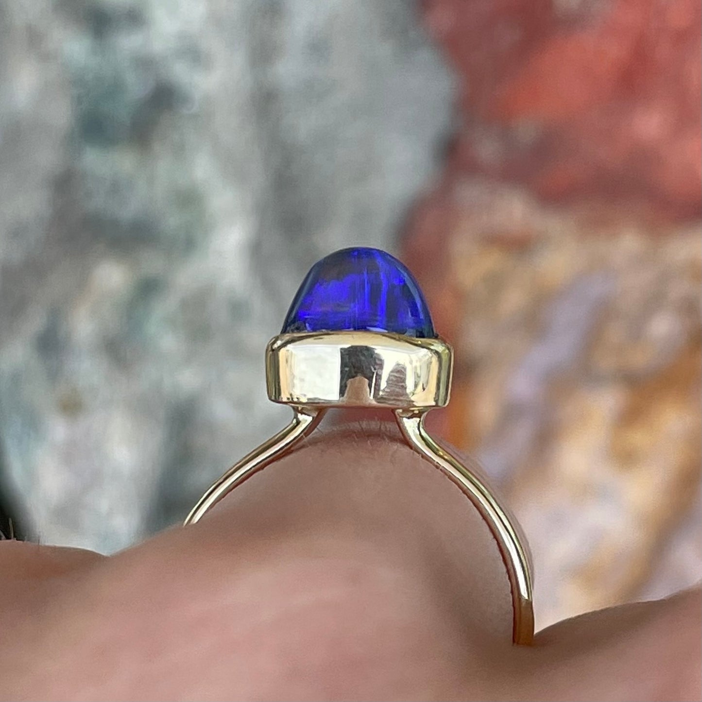 A ladies' black crystal opal solitaire ring set in yellow gold.