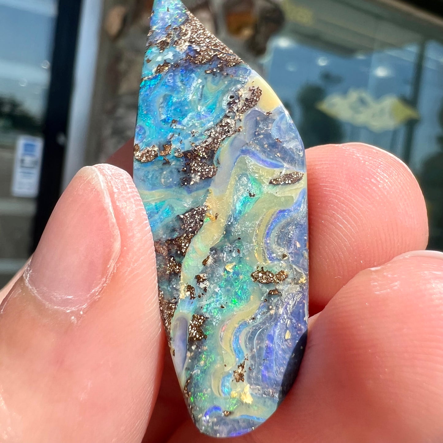 A loose Quilpie boulder opal stone. The stone is blue and has a bright rainbow tip.