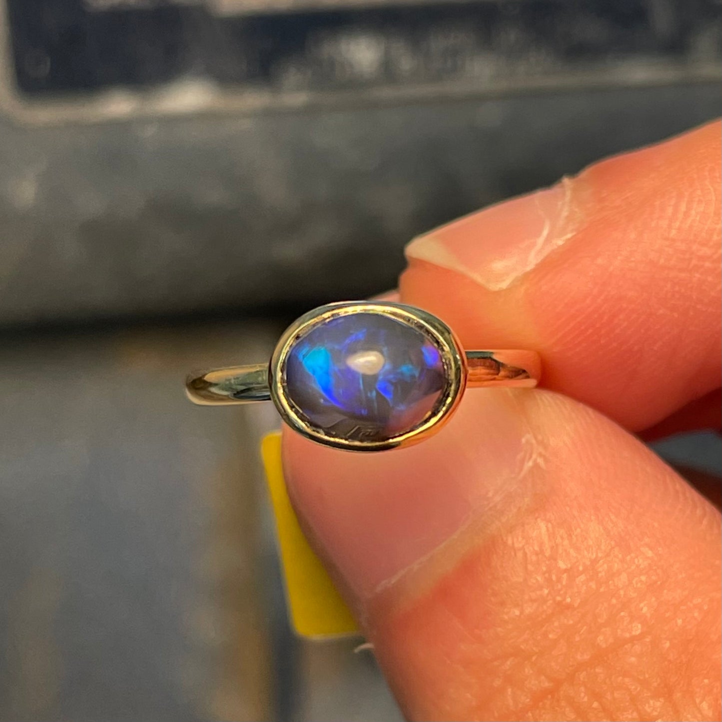 A ladies' black crystal opal solitaire ring set in yellow gold.
