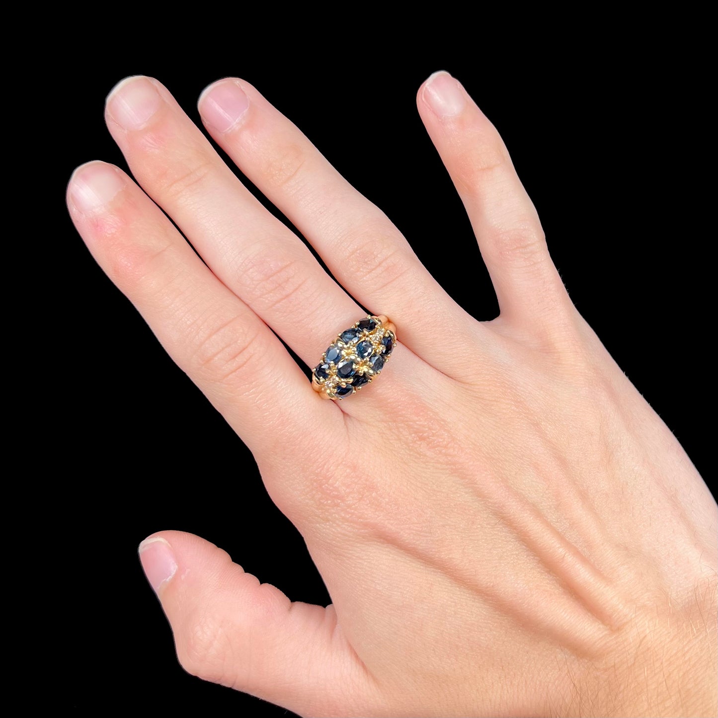 A vintage ladies' blue sapphire and diamond cluster ring cast in yellow gold.