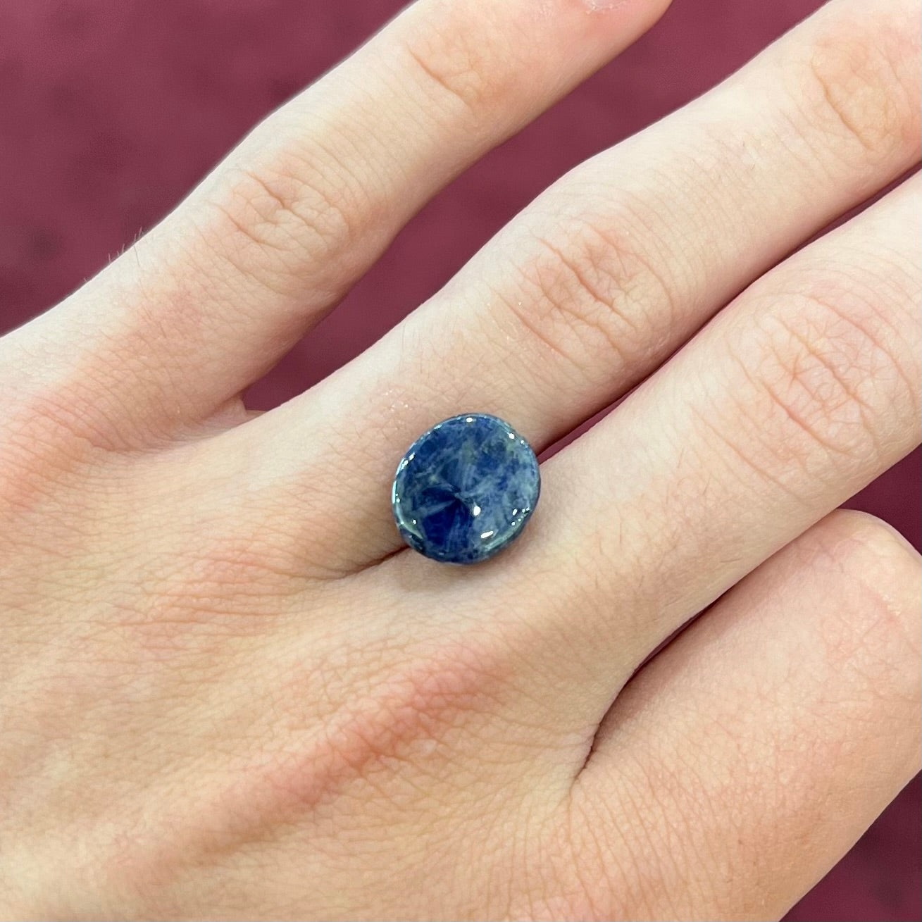 A loose, oval cabochon cut blue trapiche star sapphire stone.