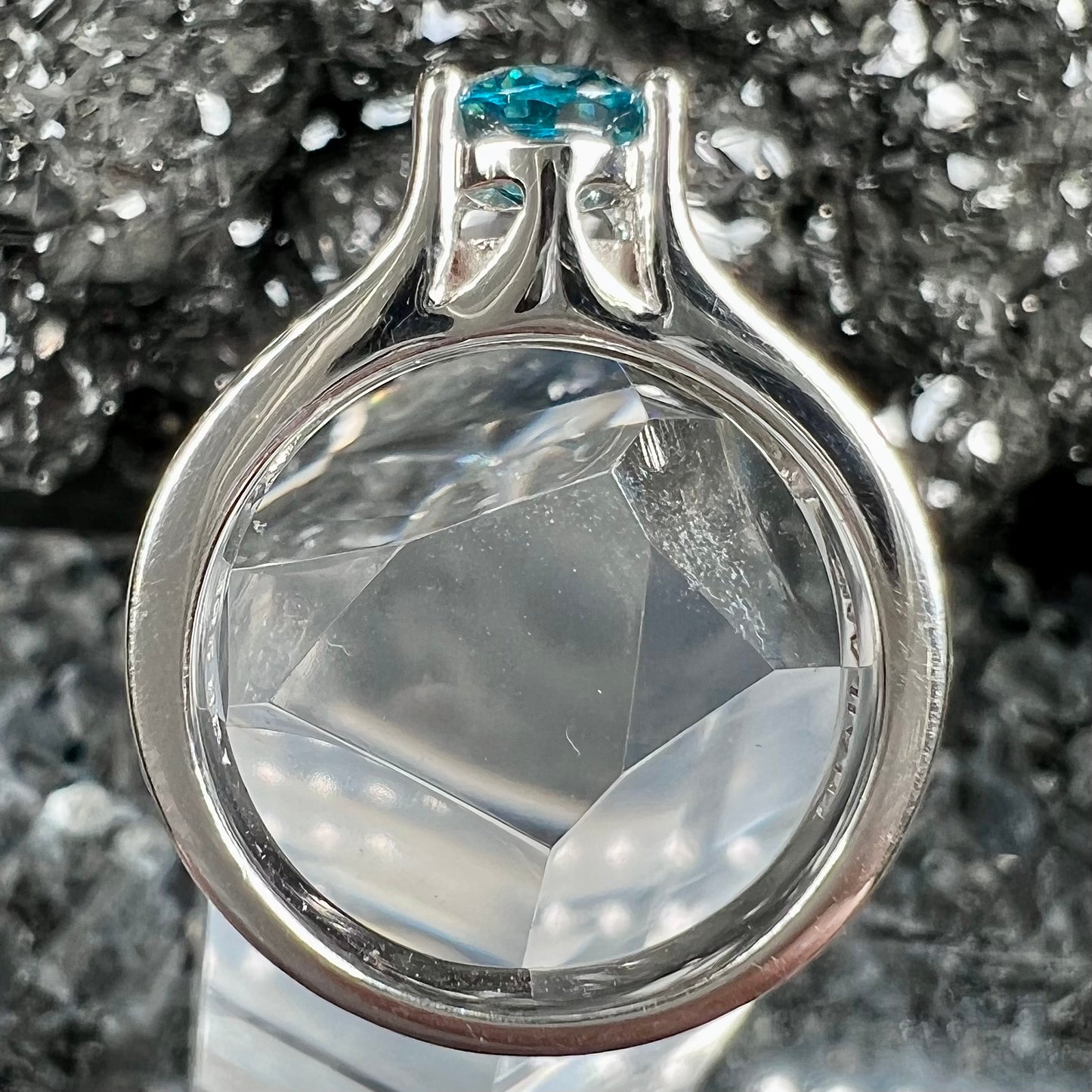 A sterling silver ring set with an oval cut blue zircon center stone and channel set white zircon accents.
