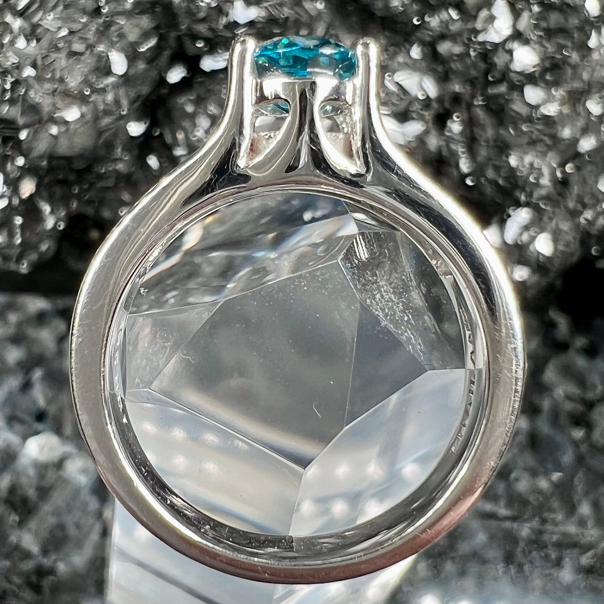 A sterling silver ring set with an oval cut blue zircon center stone and channel set white zircon accents.