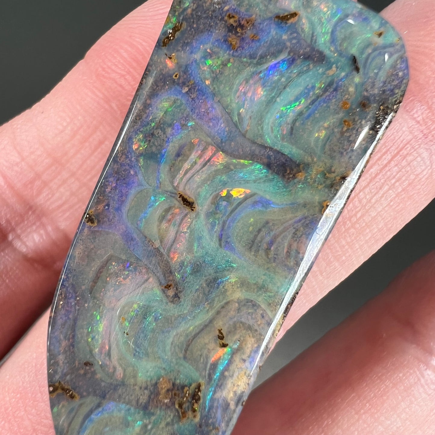 A loose, freeform cut, natural boulder opal stone from Quilpie, Australia.