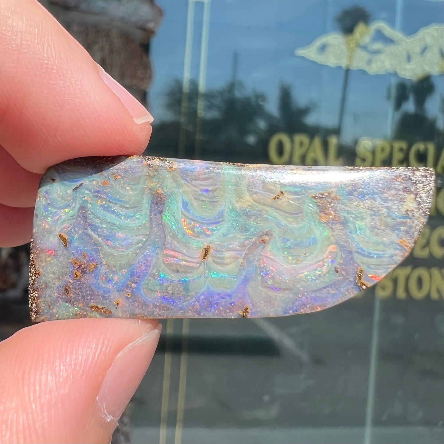 A loose, freeform cut, natural boulder opal stone from Quilpie, Australia.