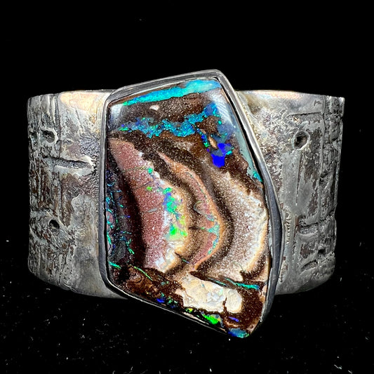 A men's sterling silver cuff bracelet set with an Australian Koroit boulder opal stone, handmade by Sam Yah.