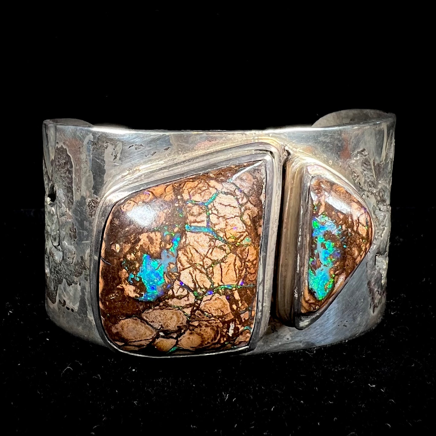 A men's sterling silver and copper infused cuff bracelet set with two boulder opal stones from Koroit, Australia.