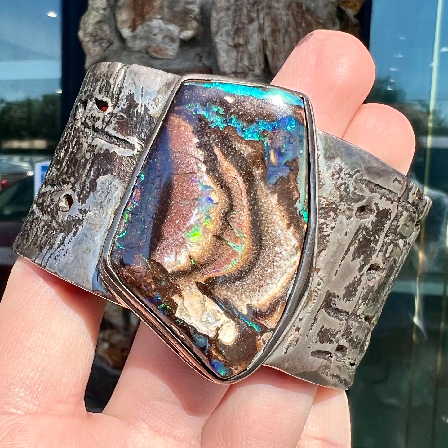 A men's sterling silver cuff bracelet set with an Australian Koroit boulder opal stone, handmade by Sam Yah.