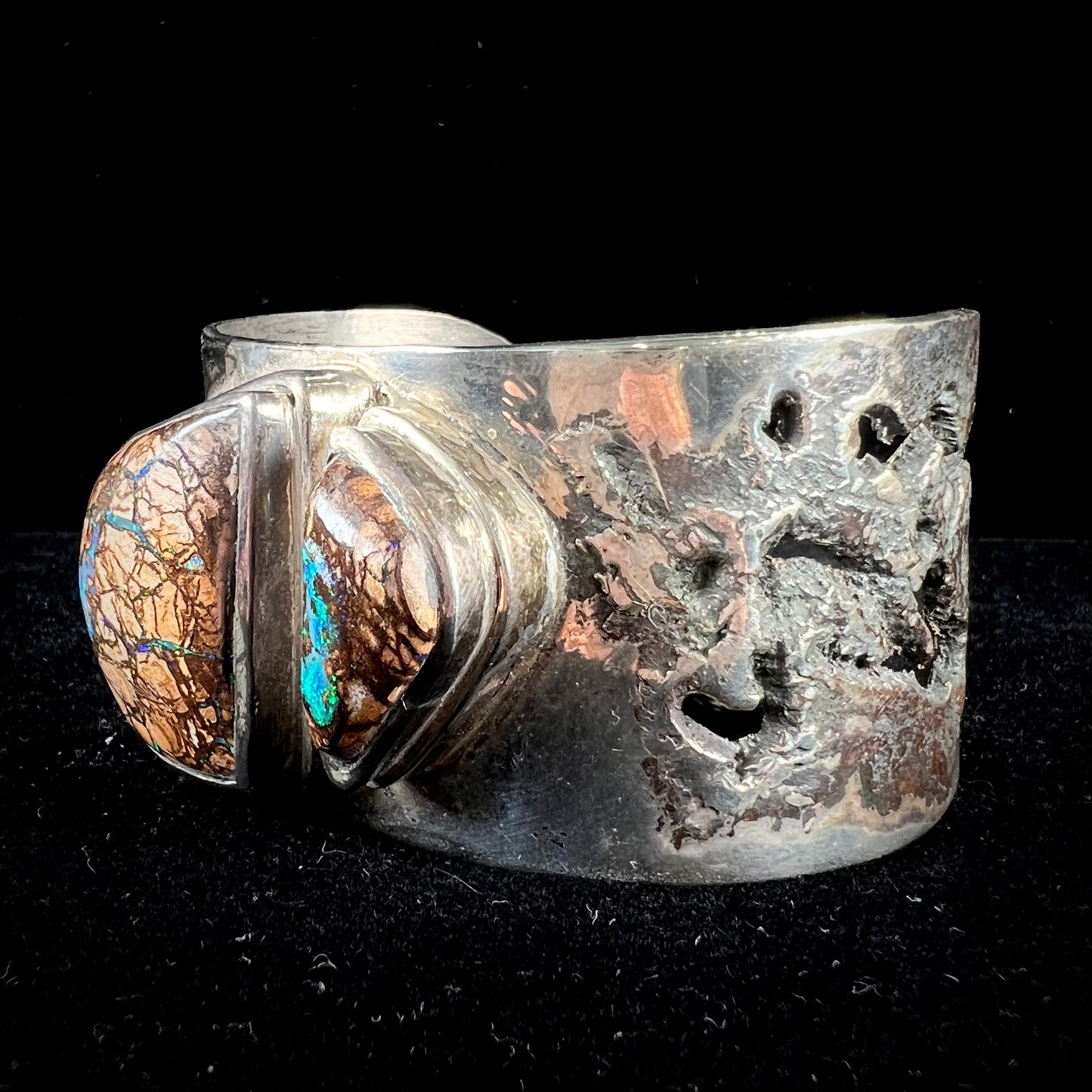 A men's sterling silver and copper infused cuff bracelet set with two boulder opal stones from Koroit, Australia.