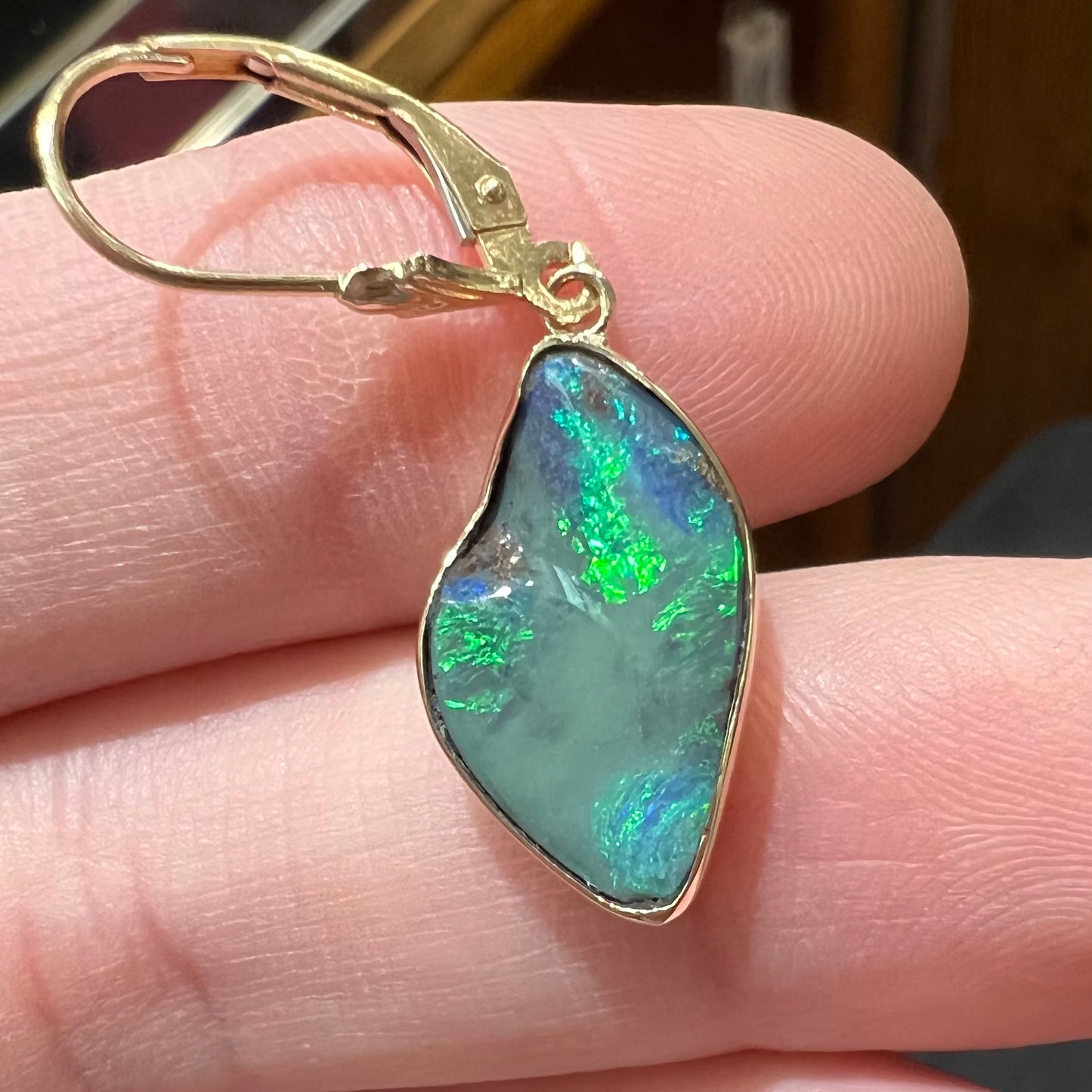 A pair of yellow gold dangle earrings set with Australian boulder opal stones.