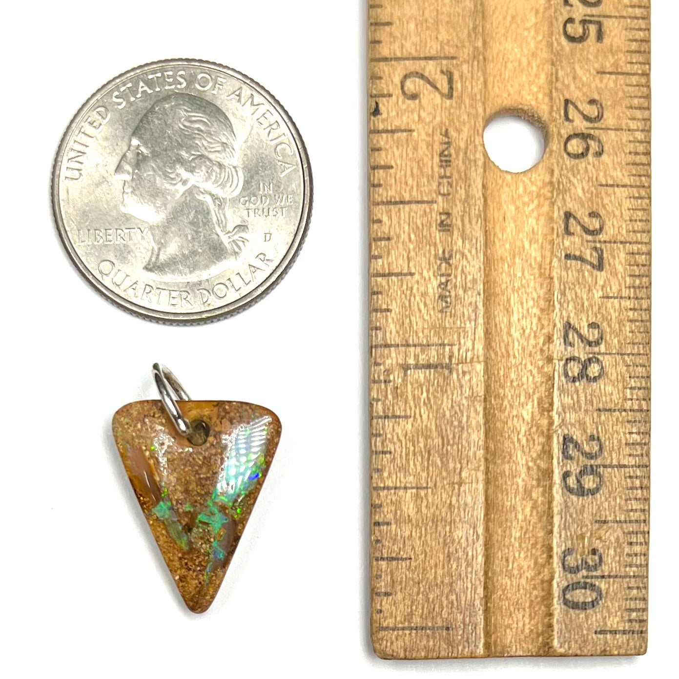 A drilled boulder opal stone with a sterling silver ring through the hole to be worn as a pendant.