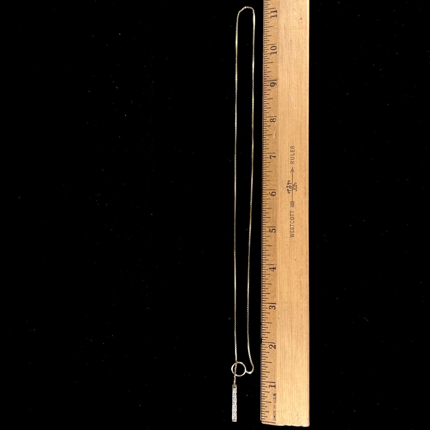 A yellow gold diamond lariat necklace on a 1mm wide box chain. The lariat is double sided.