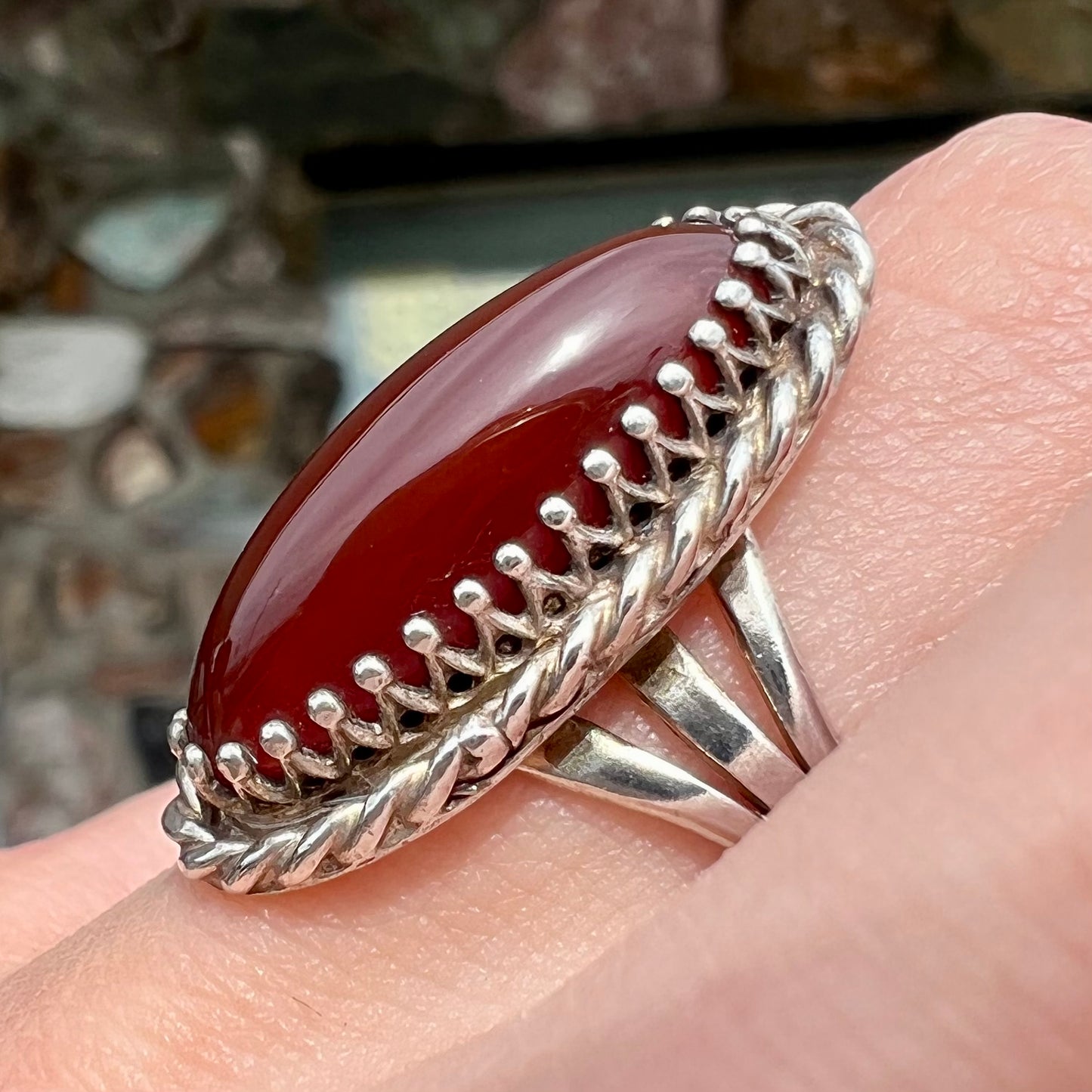 A split shank silver ring set with a brown sard stone in a rope bezel with small prongs.