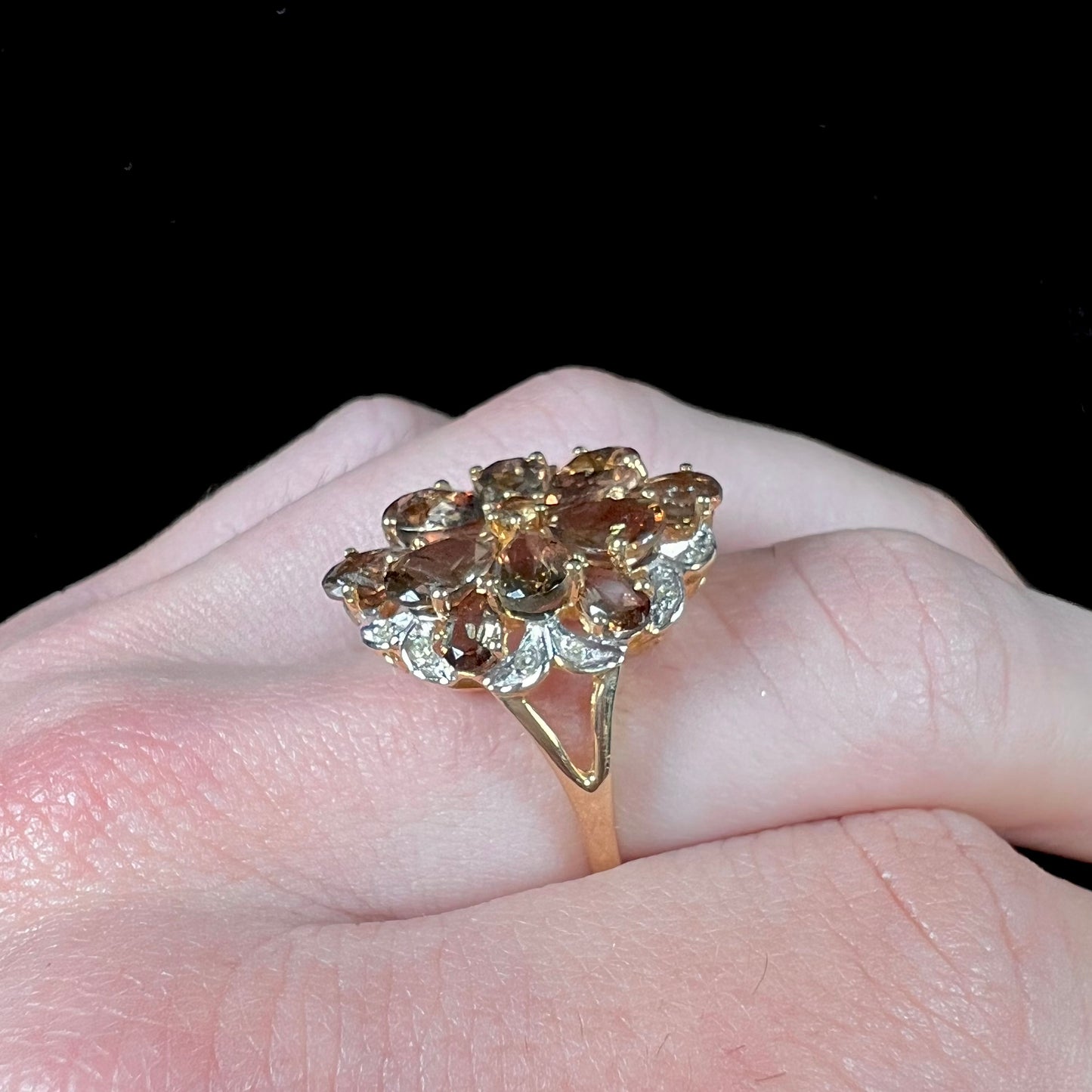 A yellow gold andalusite and diamond cluster ring.