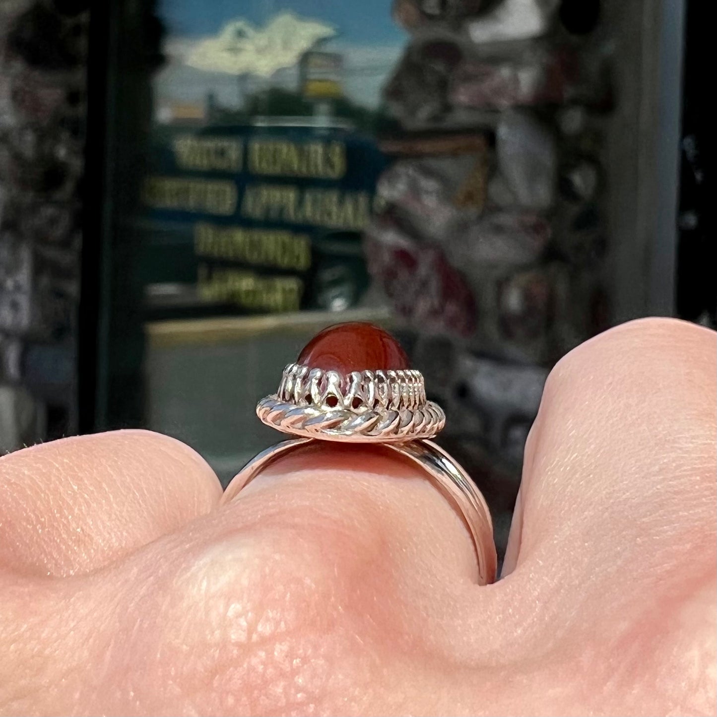 A split shank silver ring set with a brown sard stone in a rope bezel with small prongs.