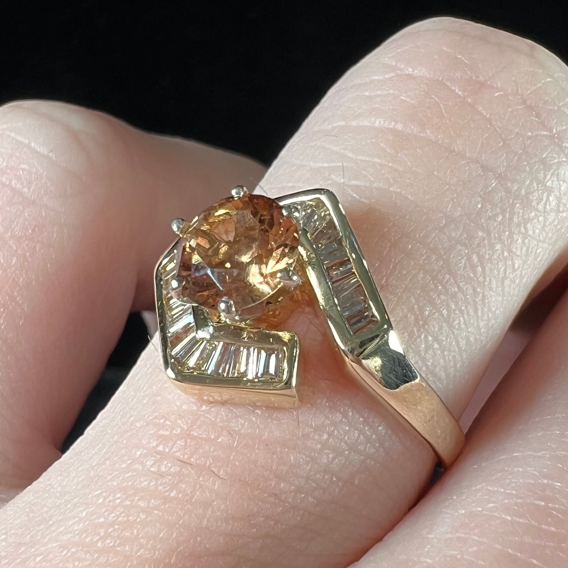 A yellow gold ladies' golden topaz ring set with baguette cut side diamonds.