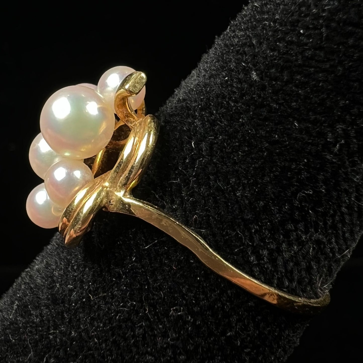 A yellow gold Akoya pearl cluster ring. The pearls are round with pink overtones and resemble bubbles.
