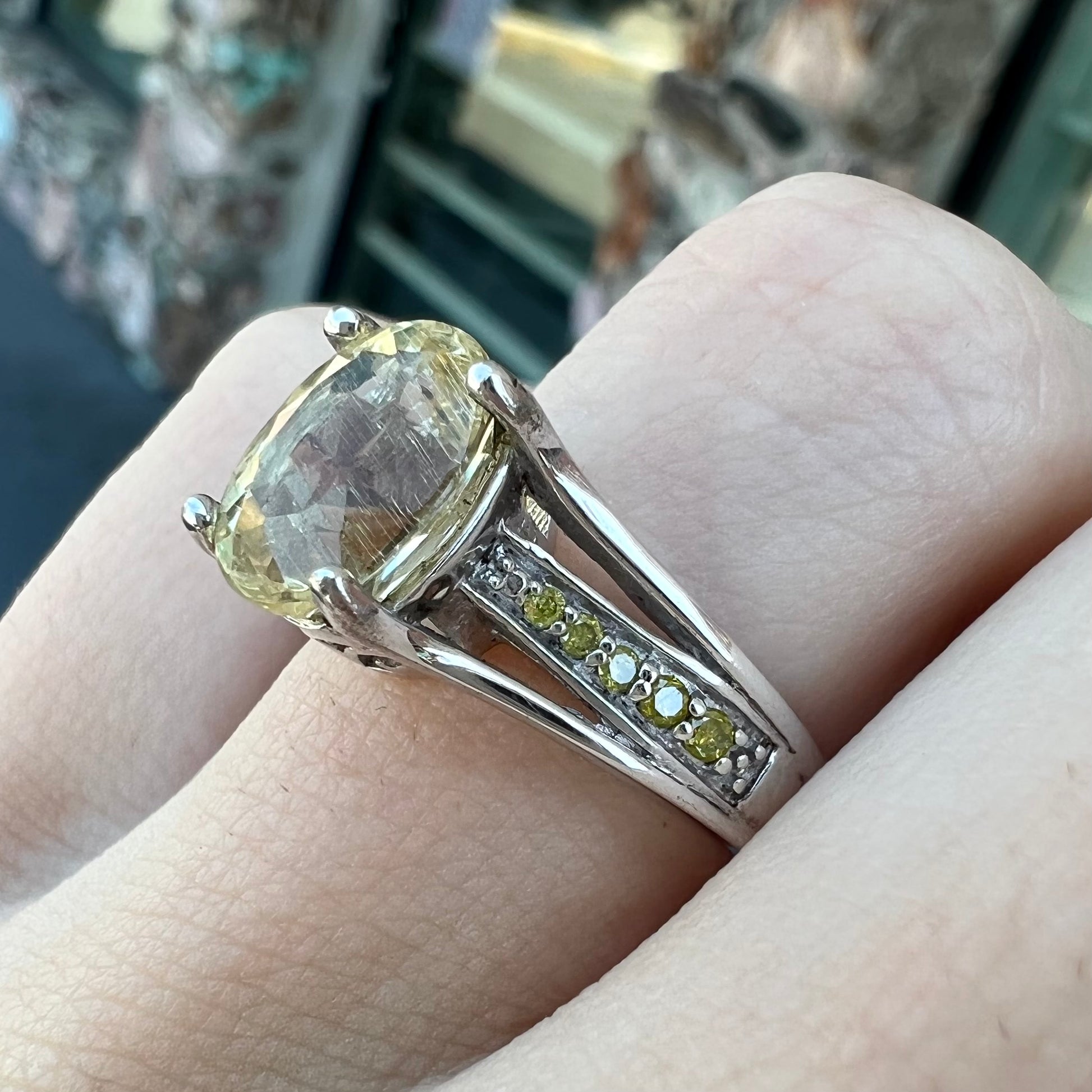 A sterling silver oval cut citrine ring set with canary yellow diamond accents.