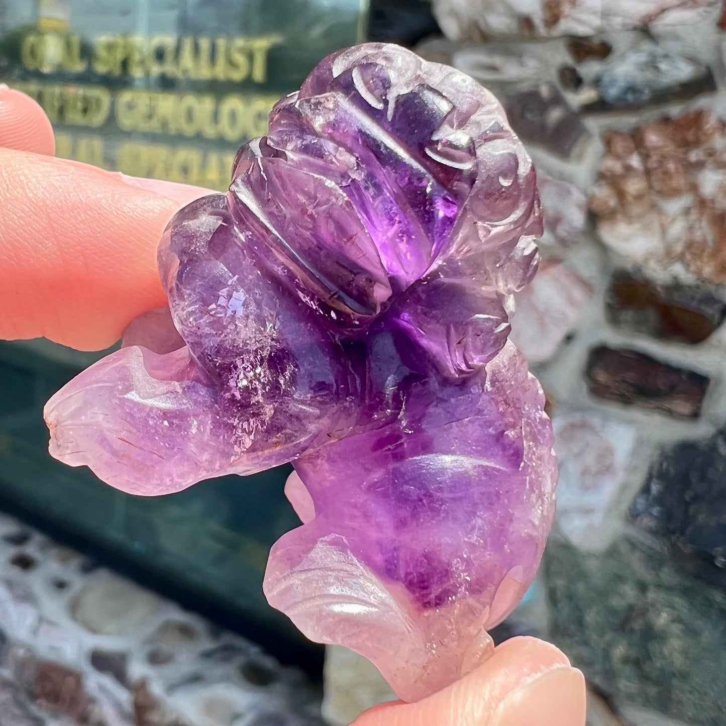 A stone foo dog carving carved from a purple Brazilian amethyst crystal.