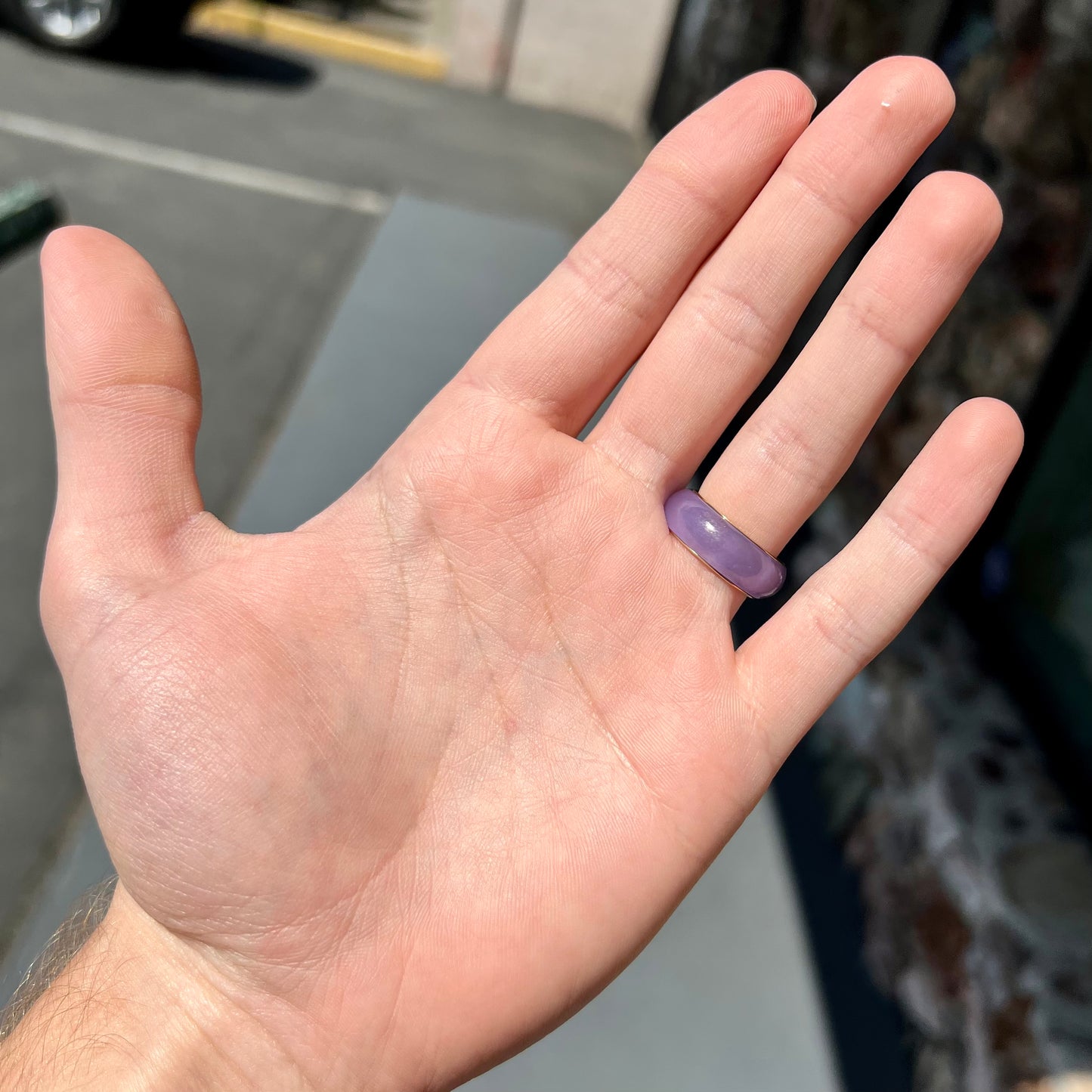 A stone ring carved from purple jadeite jade and mounted on a gold band.