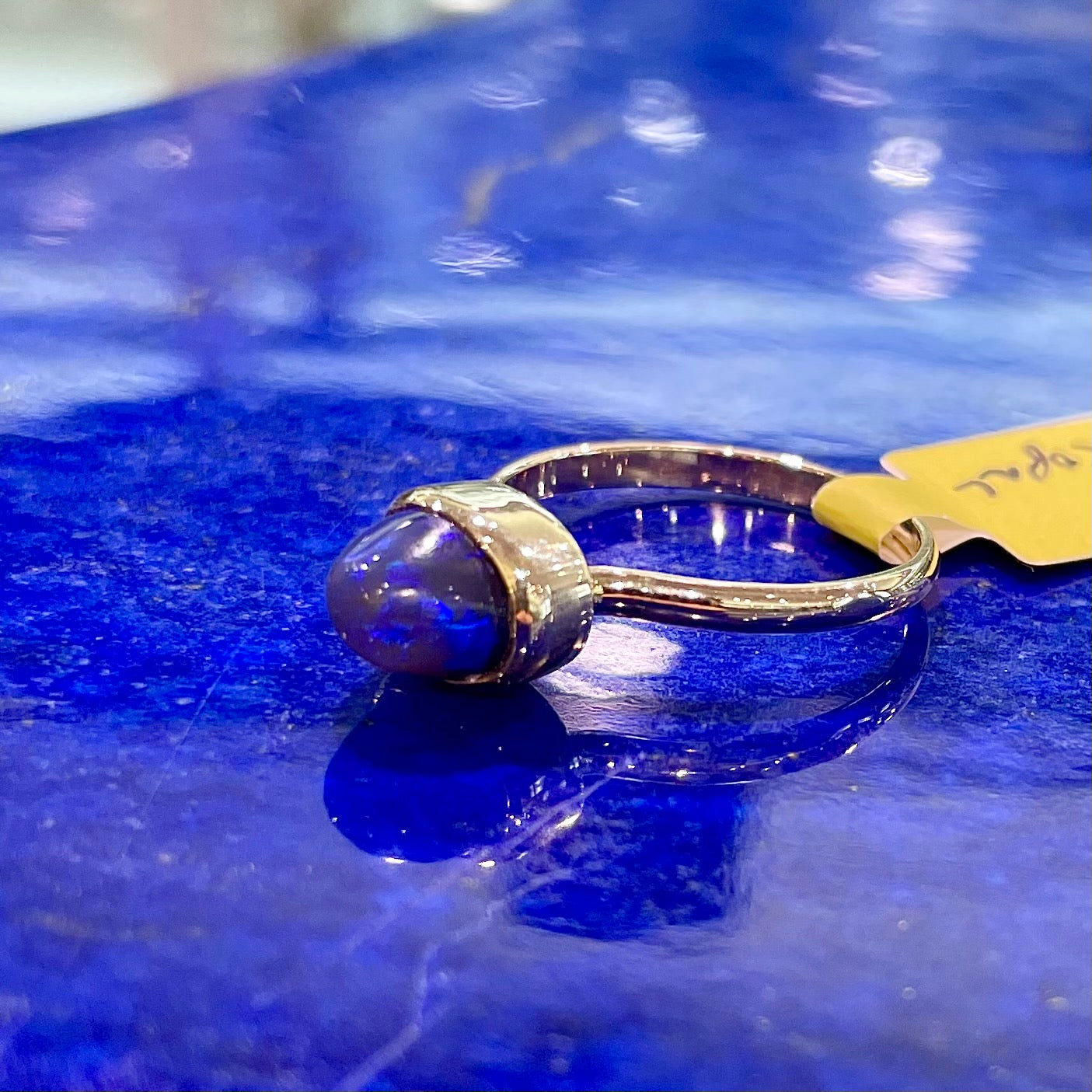 A ladies' black crystal opal solitaire ring set in yellow gold.