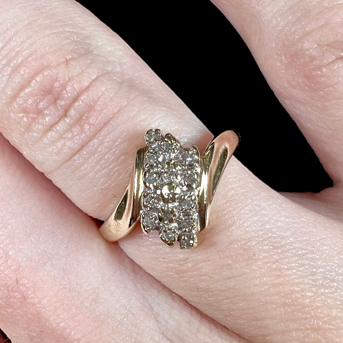 A ladies' estate yellow gold diamond cluster ring. The diamonds are round single cuts.