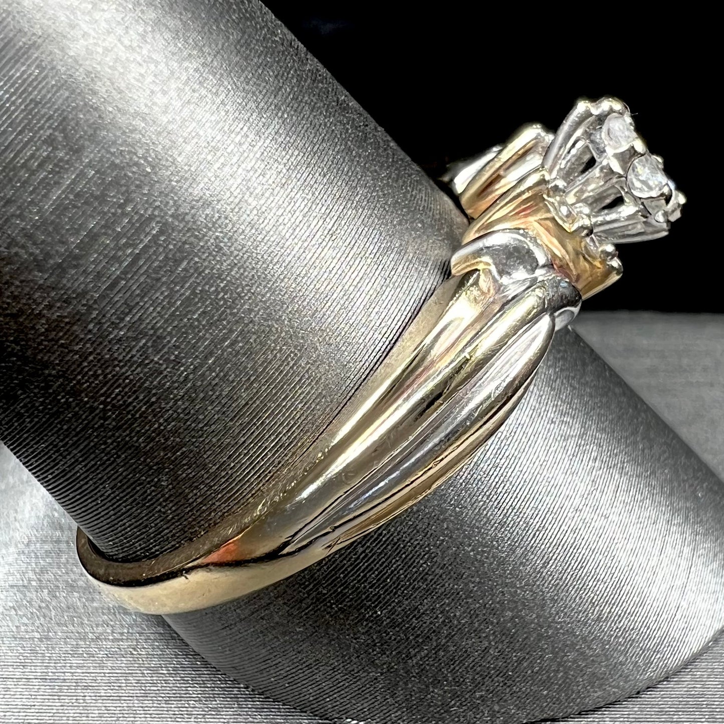 A ladies' two-tone white and yellow gold marquise cut diamond enagagement ring.  There are round diamond accents.