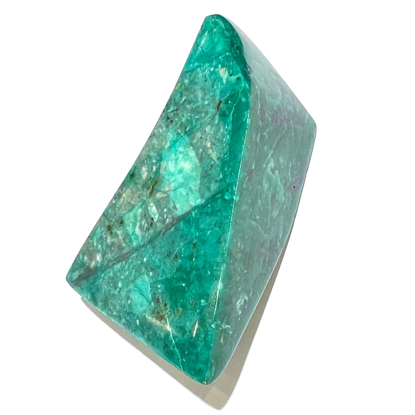 A loose polished sculpture of green chrysocolla with blue azurite inclusions.
