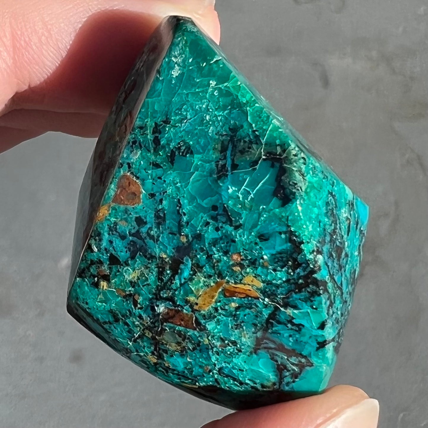 A loose polished chrysocolla specimen that has a crackled effect.