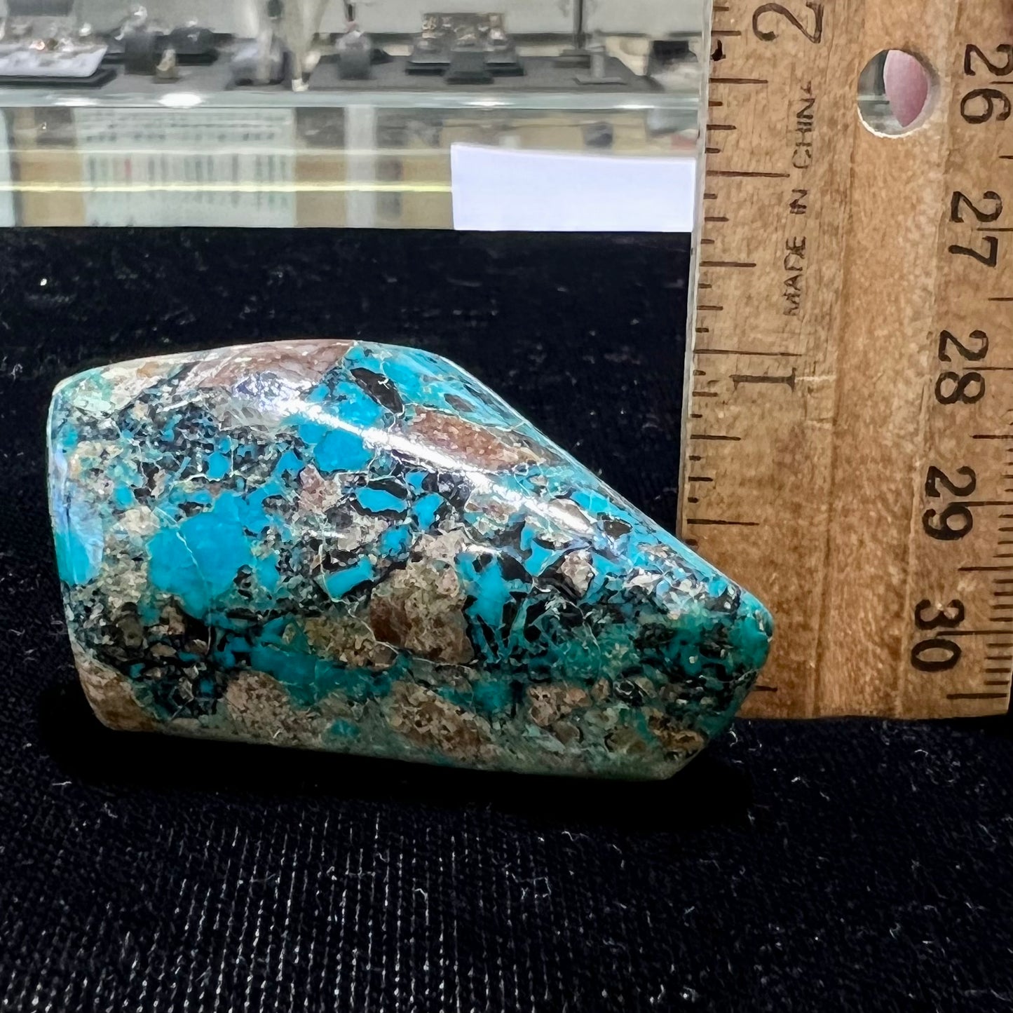 A loose polished chrysocolla stone with malachite inclusions.
