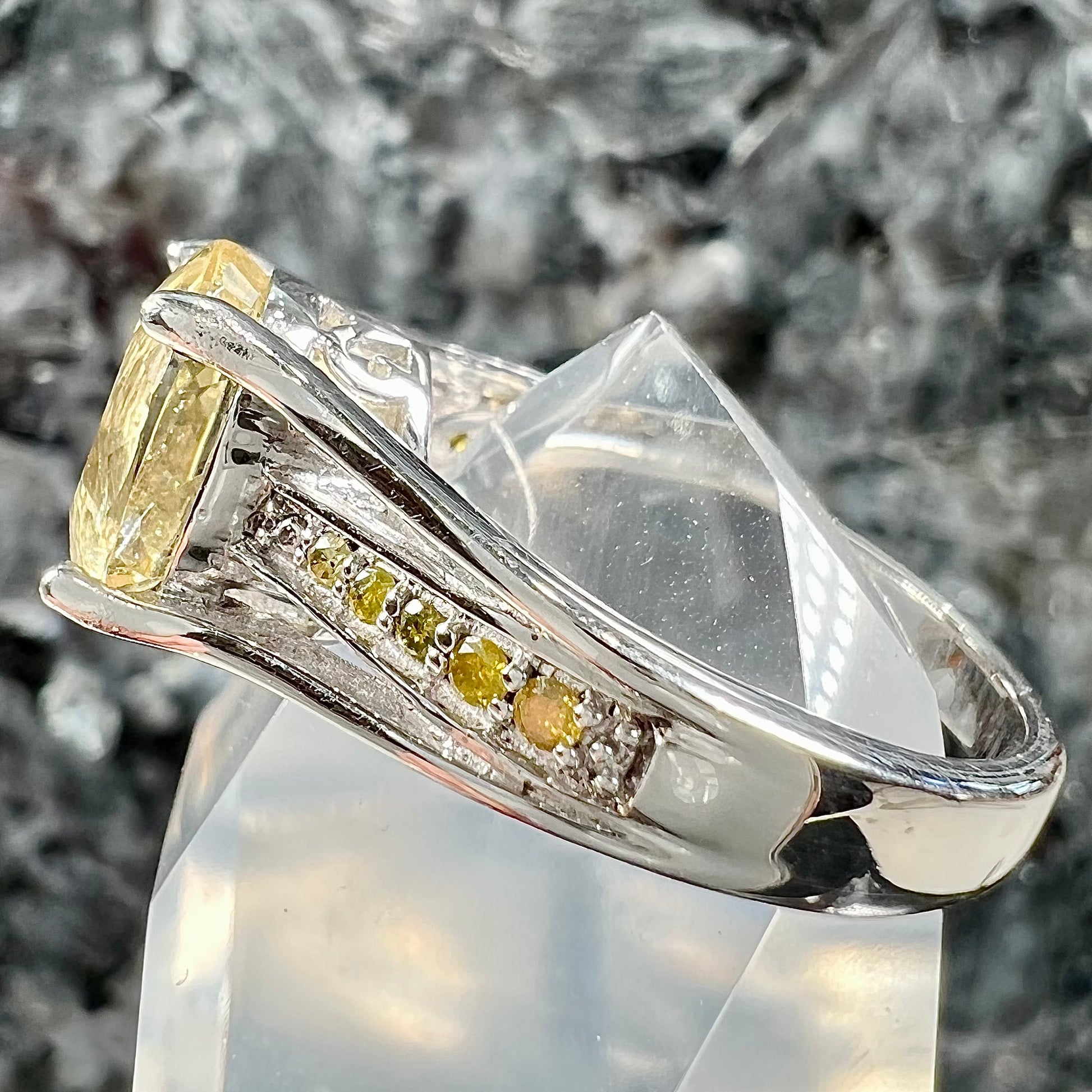 A sterling silver oval cut citrine ring set with canary yellow diamond accents.