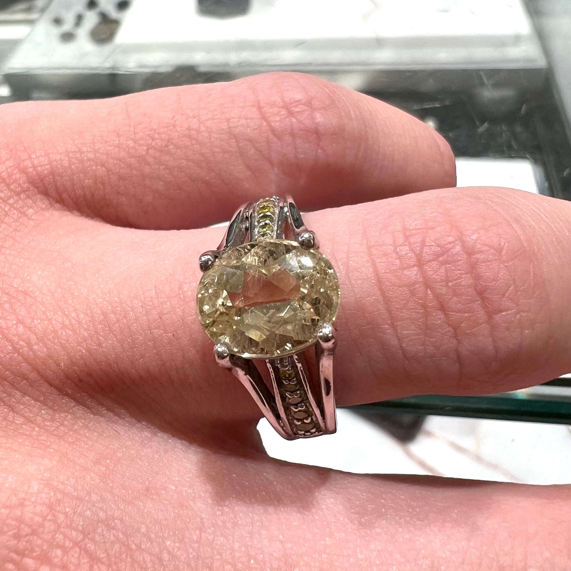 A sterling silver oval cut citrine ring set with canary yellow diamond accents.