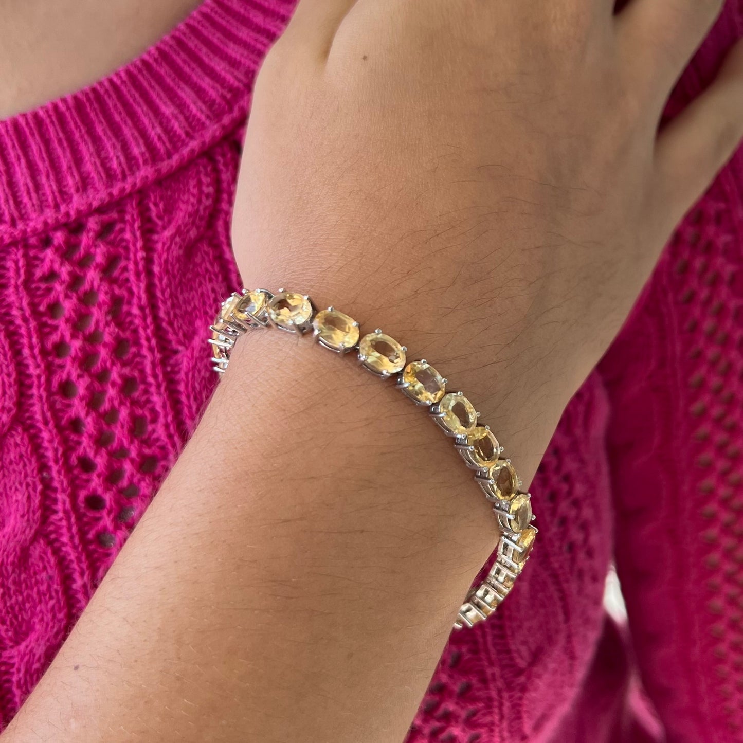 A sterling silver ladies' tennis bracelet set with faceted oval cut citrine stones.