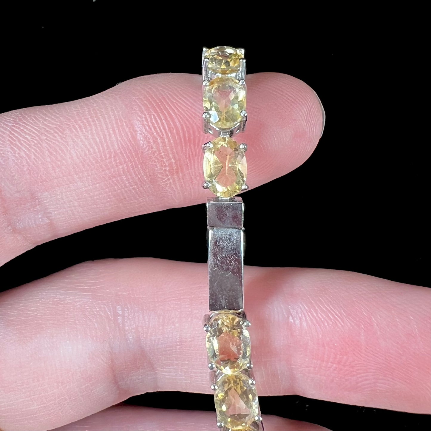 A sterling silver ladies' tennis bracelet set with faceted oval cut citrine stones.