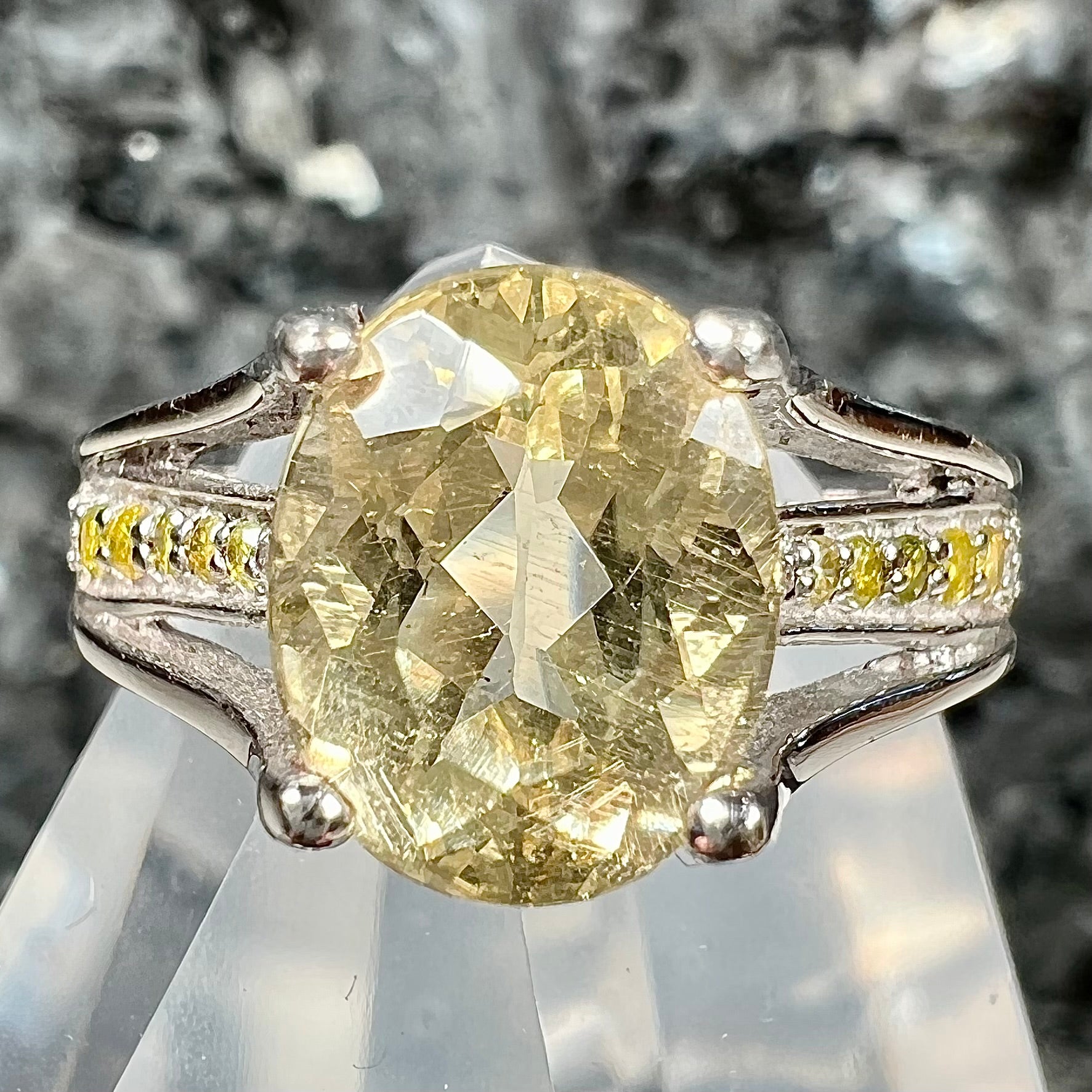 A sterling silver oval cut citrine ring set with canary yellow diamond accents.