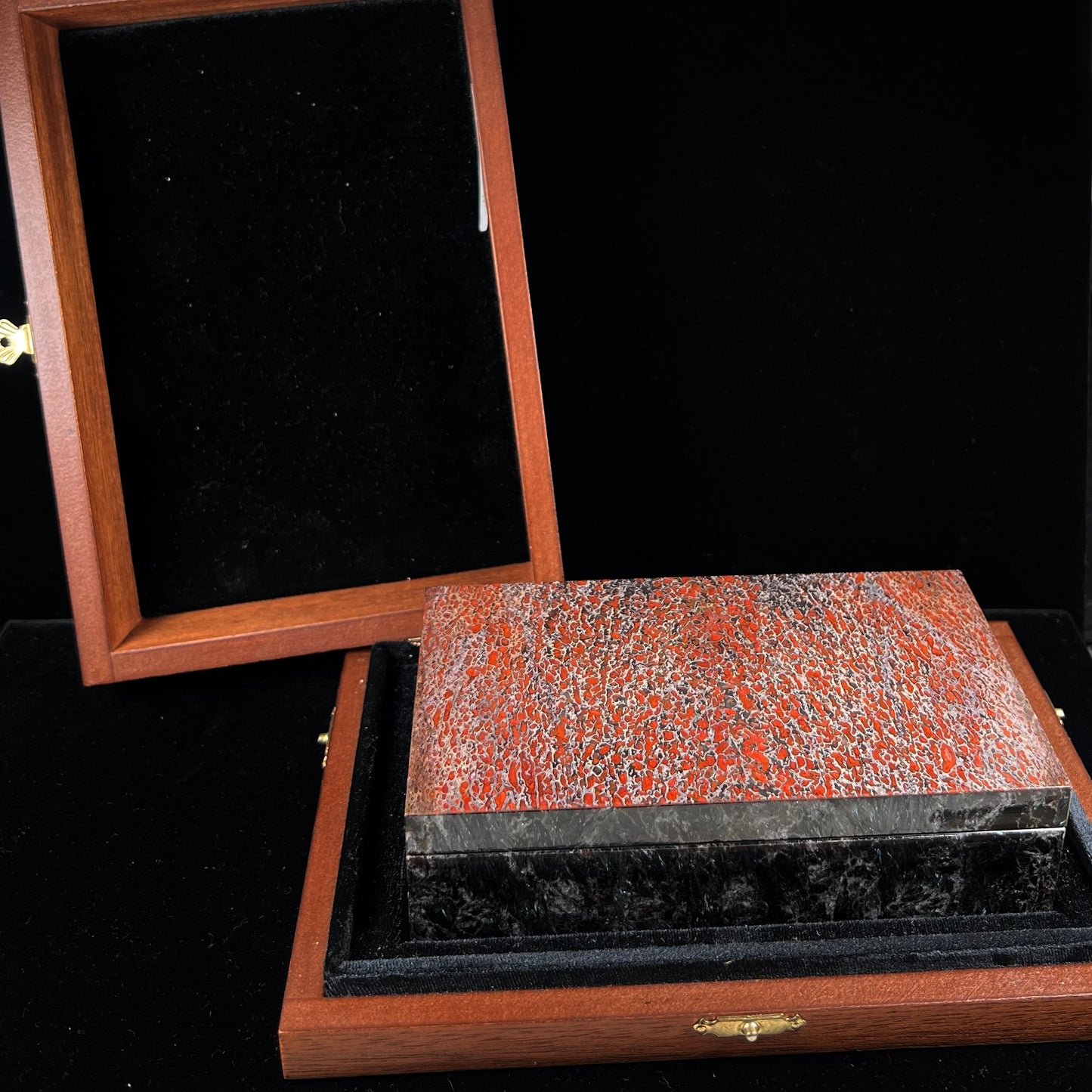 A custom stone box handmade by Gems Art Studio from polished red dinosaur bone and blue pietersite.