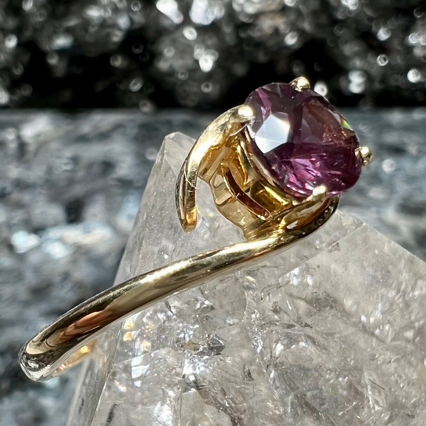A yellow gold solitaire engagement ring set with a faceted oval cut color change garnet stone.