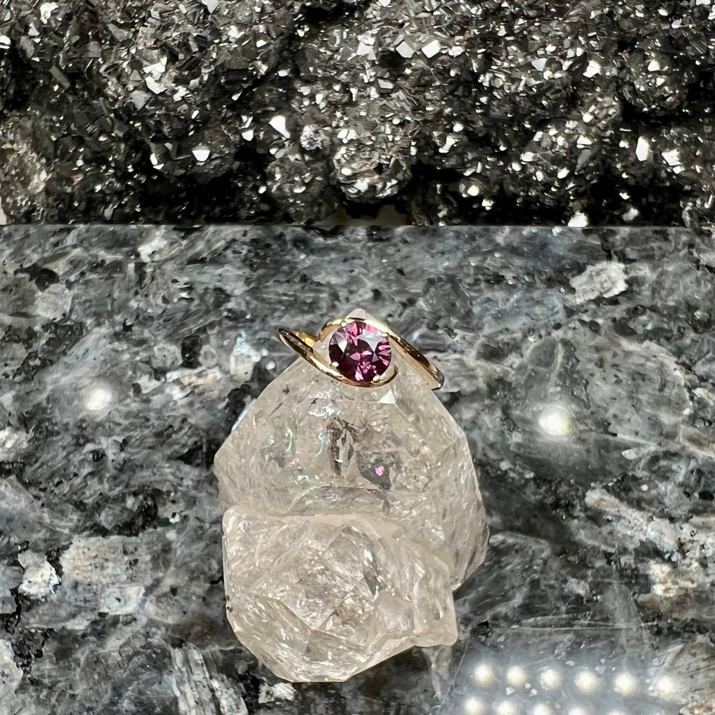 A yellow gold solitaire engagement ring set with a faceted oval cut color change garnet stone.