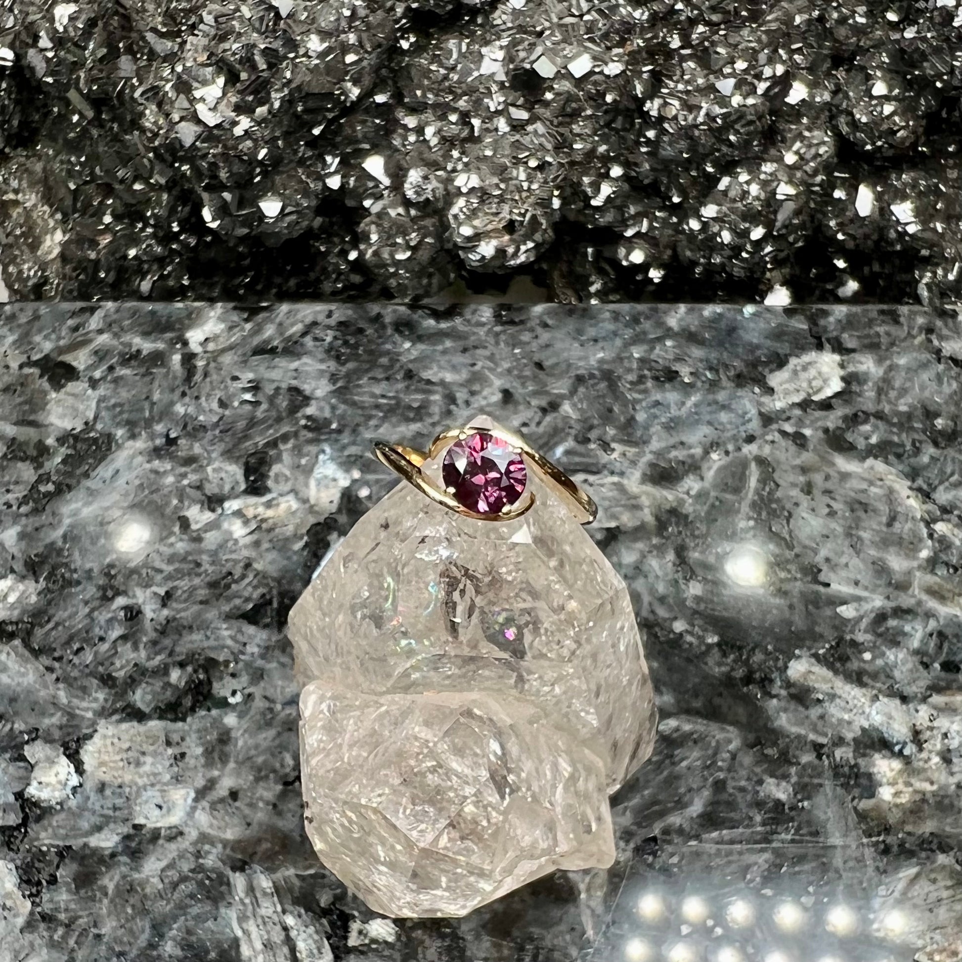 A yellow gold solitaire engagement ring set with a faceted oval cut color change garnet stone.
