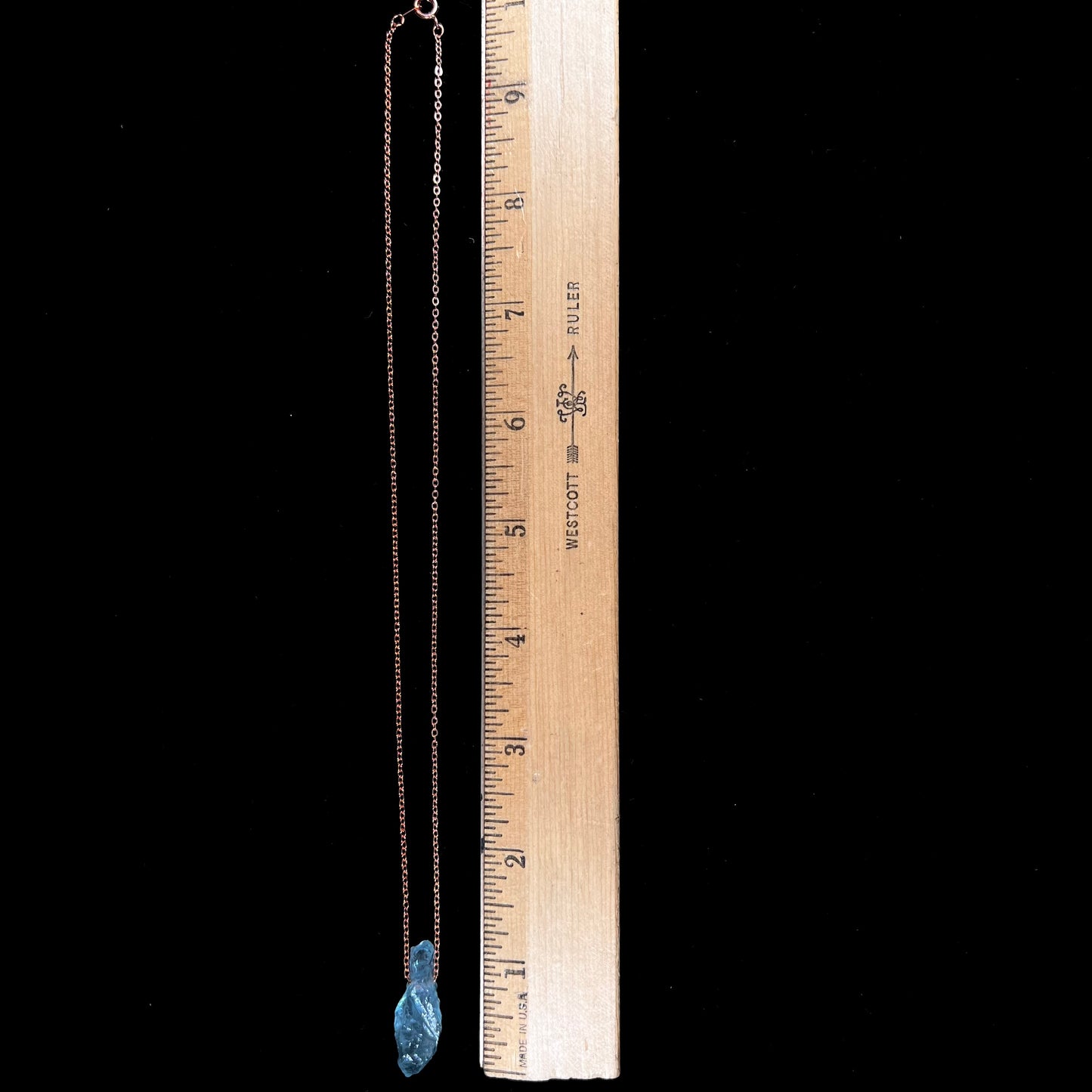 A drilled aquamarine crystal necklace on a copper cable chain.