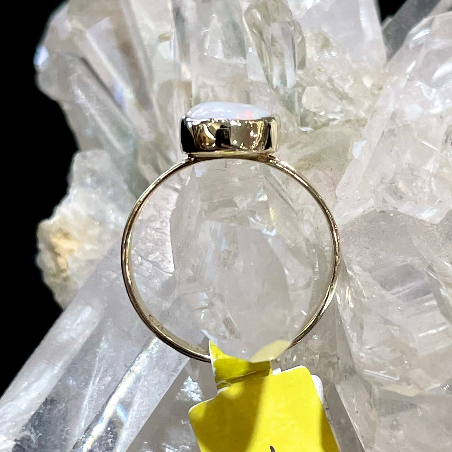 A handmade split shank white opal solitaire ring in yellow gold.