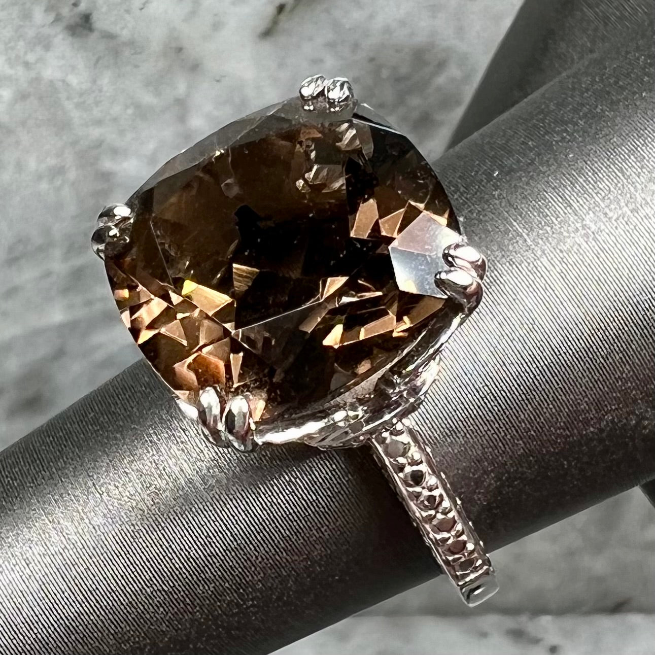 A sterling silver, cushion cut smoky quartz solitaire ring.