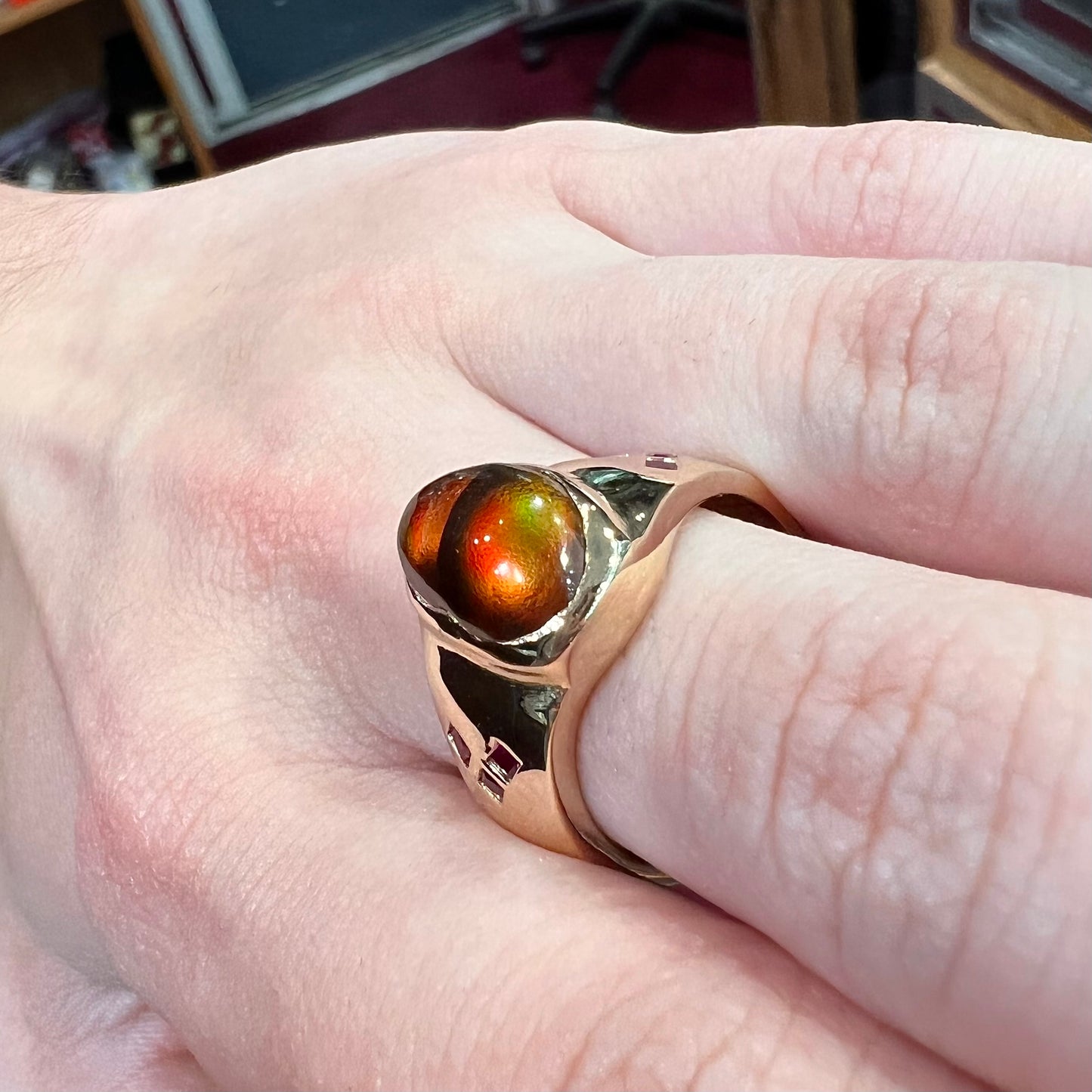 A yellow gold men's ring set with princess cut Burma rubies and a freeform cabochon cut red fire agate from Slaughter Mountain, Arizona.