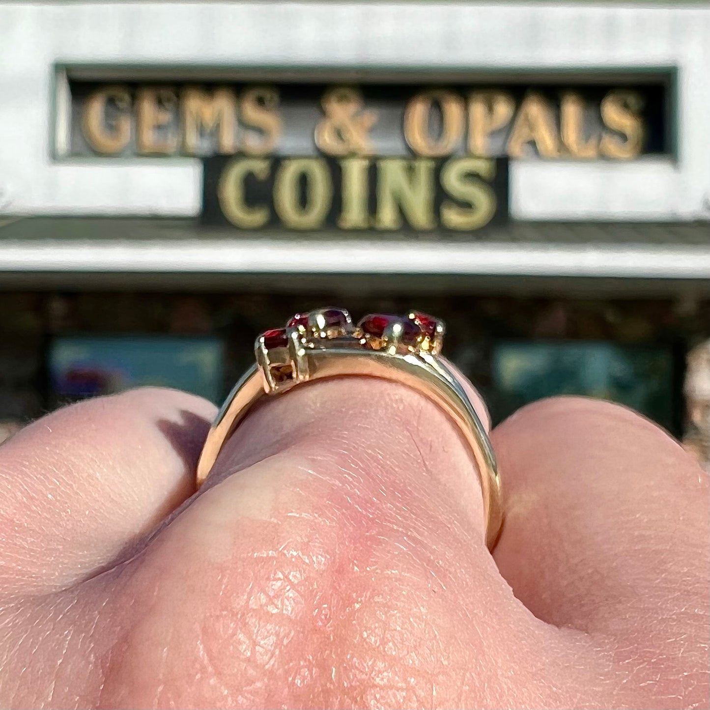A yellow gold multishank ring set with two heart shape and two round cut red garnets.