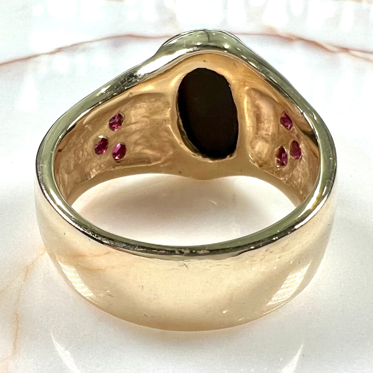 A yellow gold men's ring set with princess cut Burma rubies and a freeform cabochon cut red fire agate from Slaughter Mountain, Arizona.