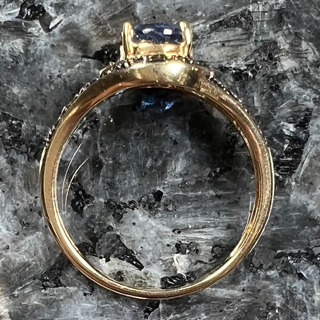 A ladies' oval cut blue kyanite twist ring pave set with blue and white diamond accents.
