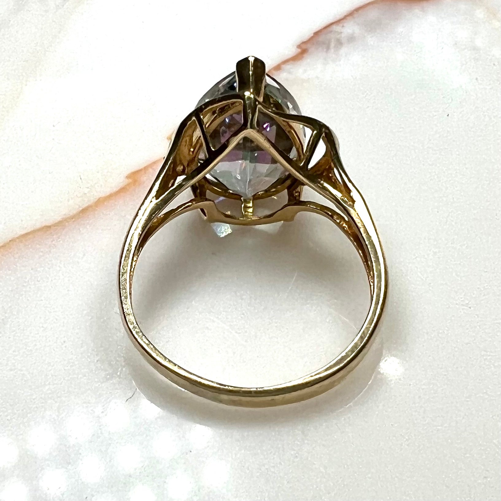 Pear shape green and pink mystic topaz set in a yellow gold ring with a single round diamond.