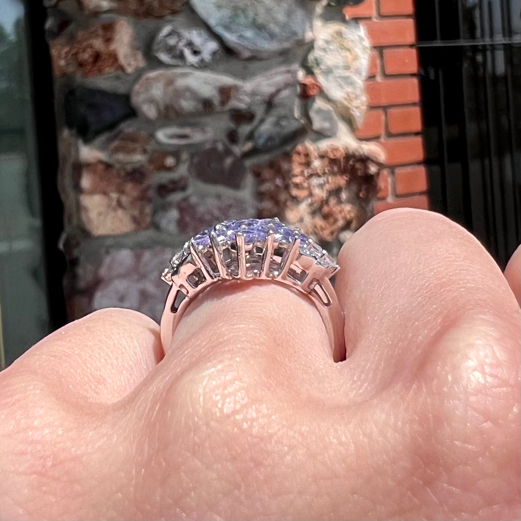 A sterling silver gemstone cluster ring set with oval cut tanzanite stones and round cubic zirconia accents.