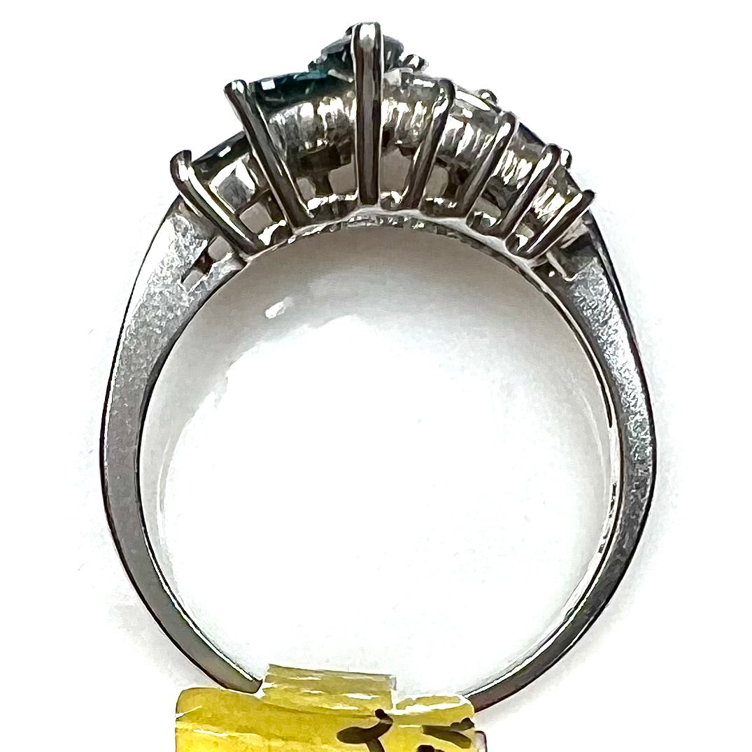 A white gold diamond cluster ring set with blue marquise cut and white round cut diamonds.