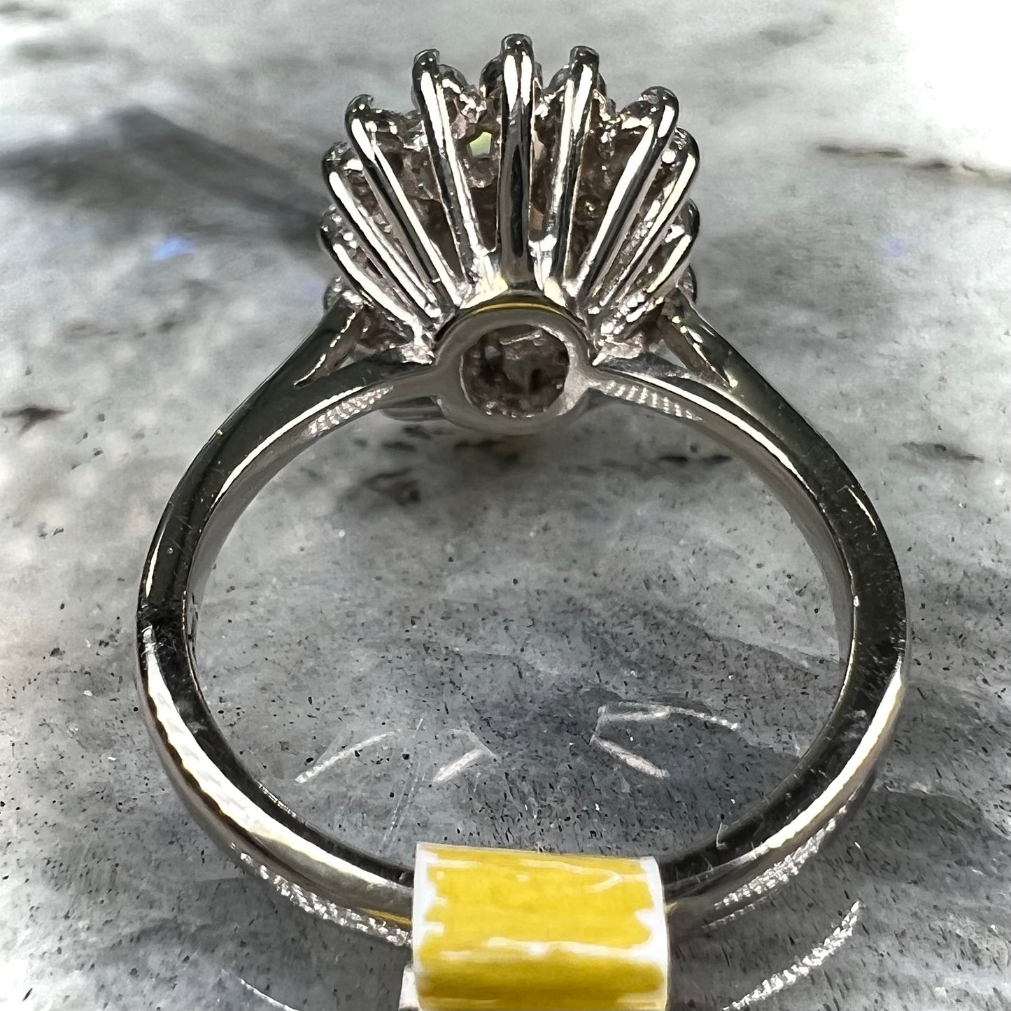 A white crystal opal ring cast in white gold with a halo of round cut diamonds.
